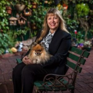 Photo of author Helen Milroy with dog on a bench